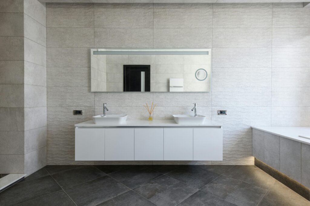 Modern bathroom with dark stone floors and a white vanity. Cleaned to perfection by Soul Cleaners