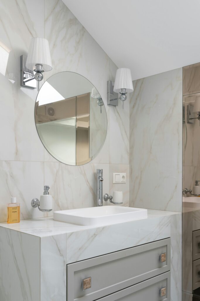 The best apartment cleaning in Denver. Clean vanity with a circular mirror over it.