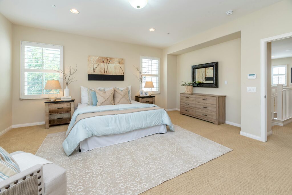 Beautiful spotless bedroom with a rug underneath the bed. Professionally cleaned by Soul Cleaners.